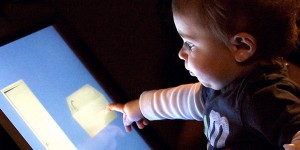 baby touching monitor in lab