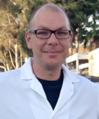 Nathen Murawski in lab coat outside