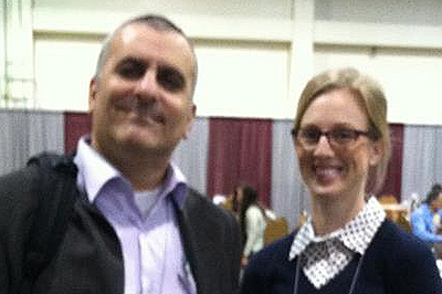 Dr. Nader Amir and Kristen Frosio standing at symposium