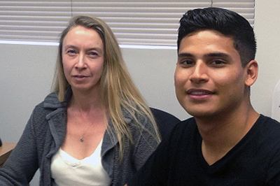 Dr. Susan Brasser and Carlo Quintanilla sitting in office.